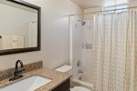 The en-suite bathroom has a single vanity and a bath/shower combo